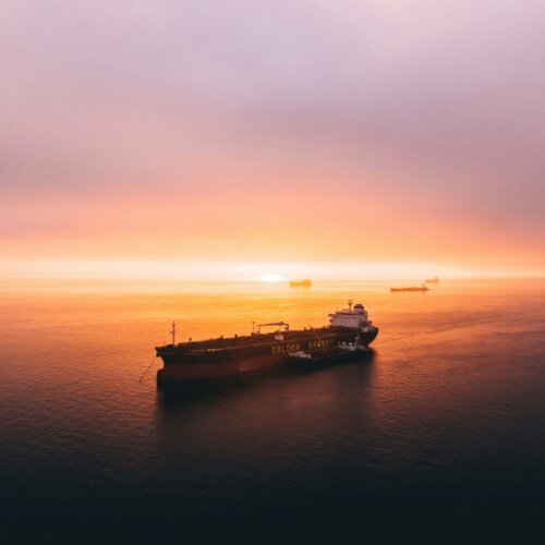 Frachtschiff auf hoher See im Sonnenuntergang