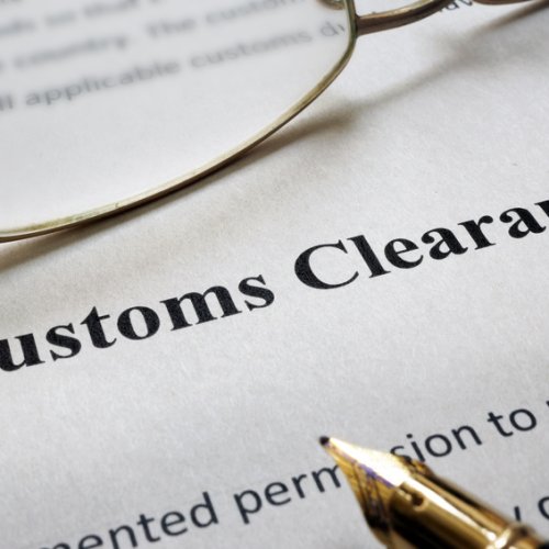 Page of paper with words Customs Clearance and glasses.